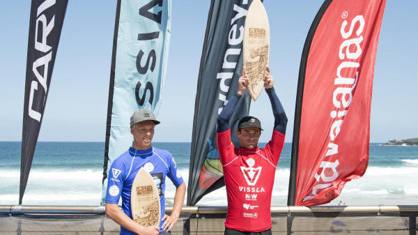 Cam Richards holds contest victory trophy over head.
