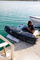 Ben Weiland wheeled coffin surfboard travel bag on boat.