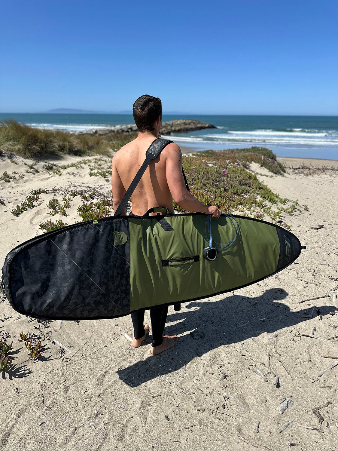 eithan osborne at beach with session surfboard day bag