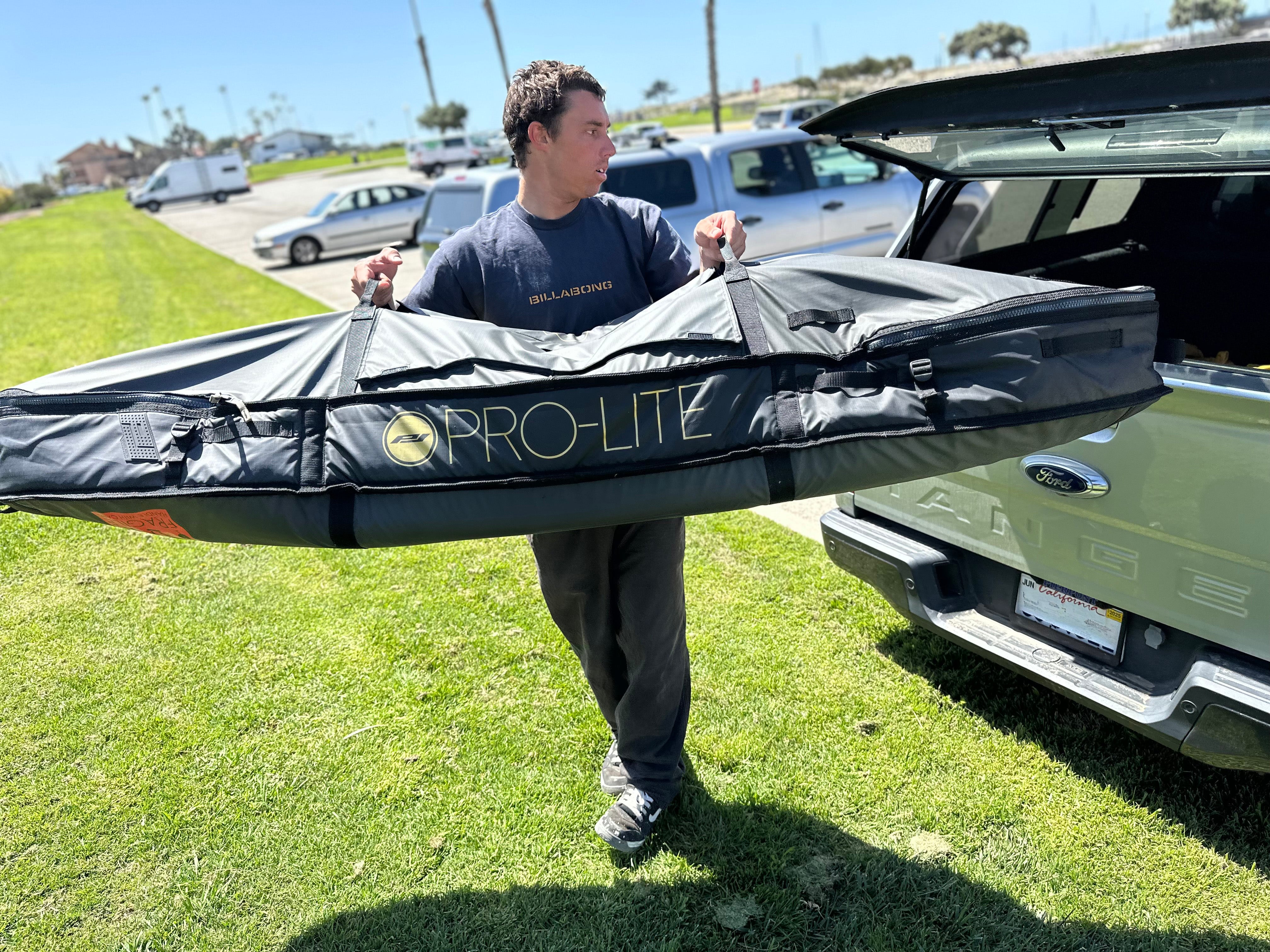 eithan osborne loading finless coffin surfboard travel bag in truck