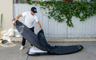 Josh Kerr placing a board in the Rhino surfboard travel bag for 1-2 boards.