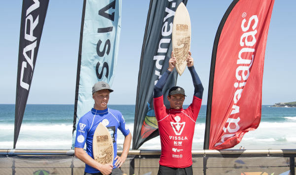 Cam Richards holds contest victory trophy over head.