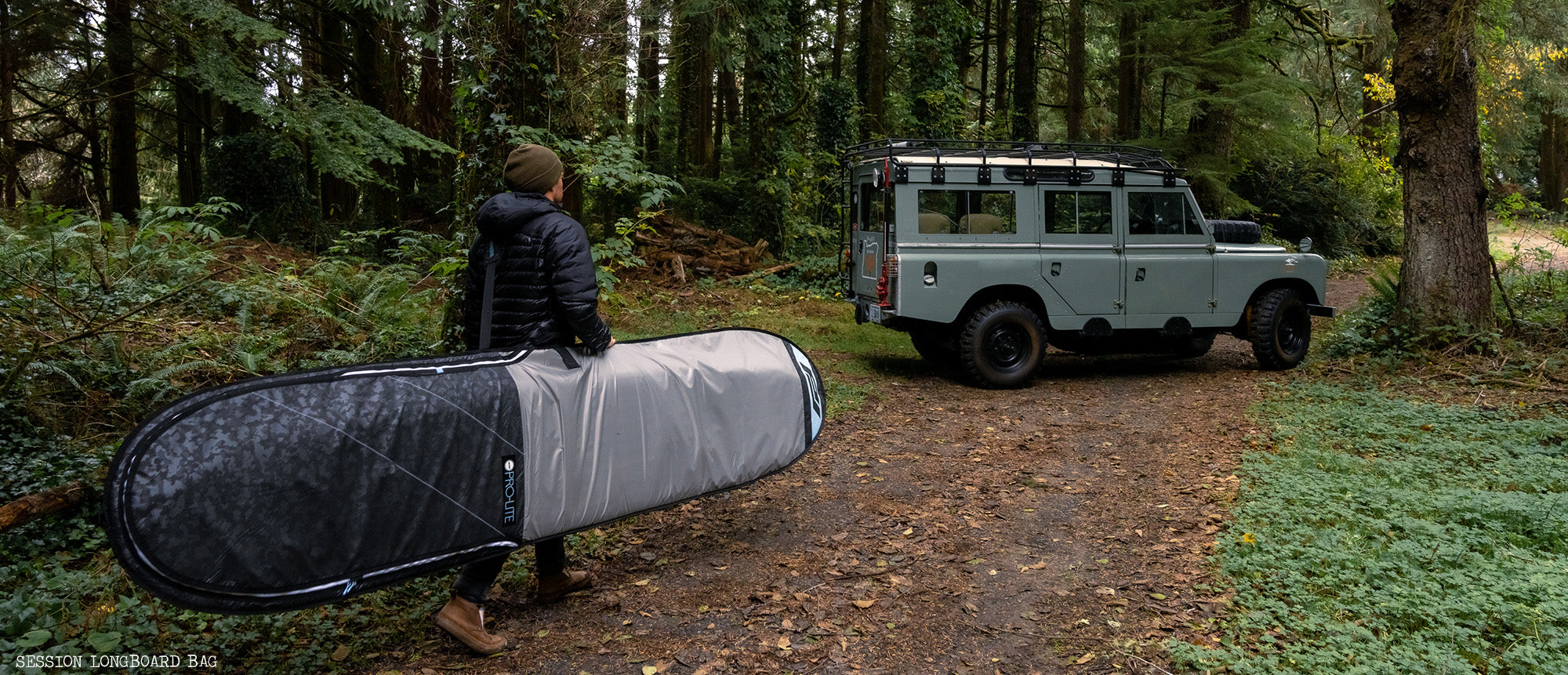 Person walks in forest with session longboard day bag.