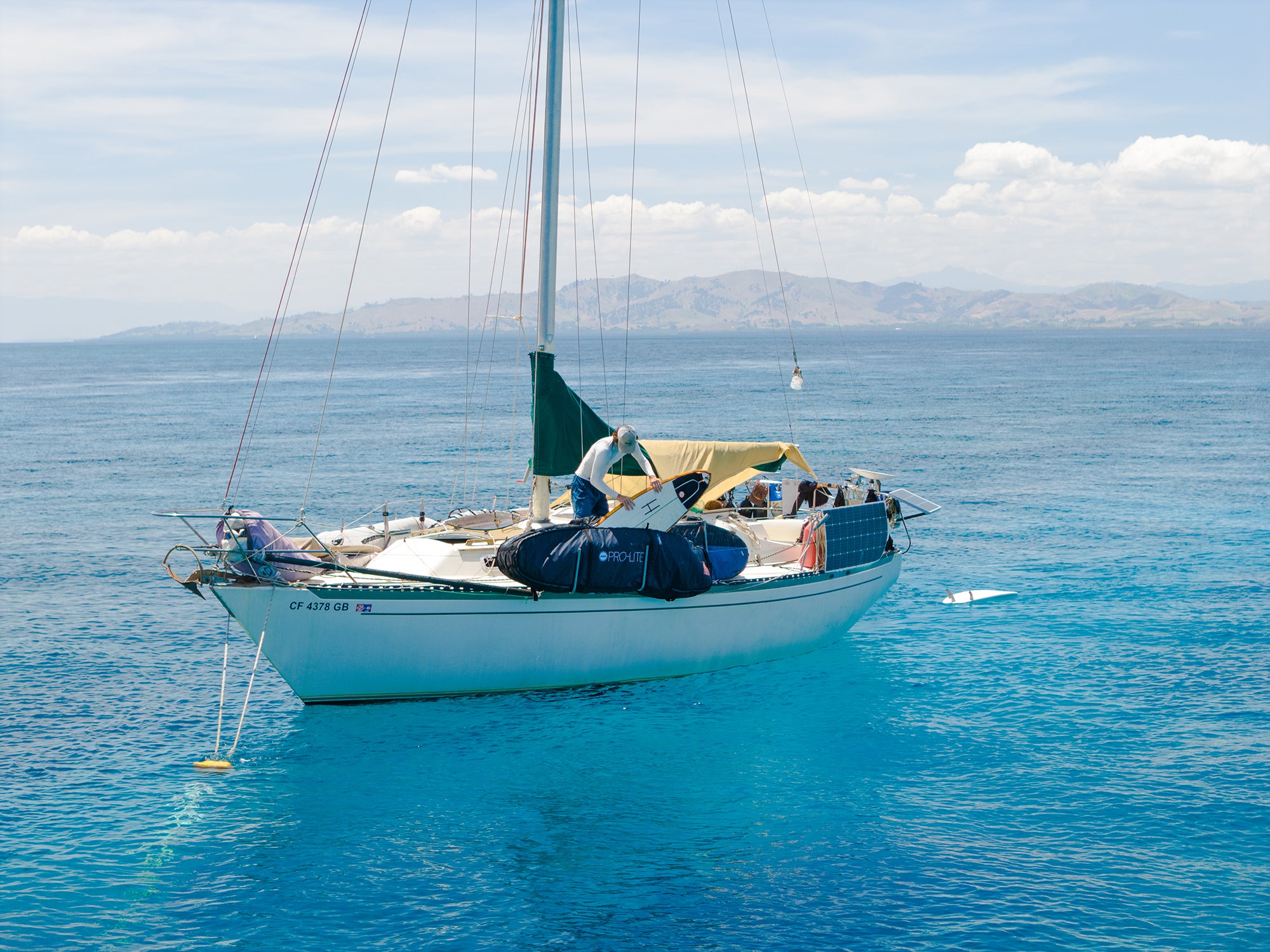surfer places board into prolite wheeled coffin travel bag in Fiji.