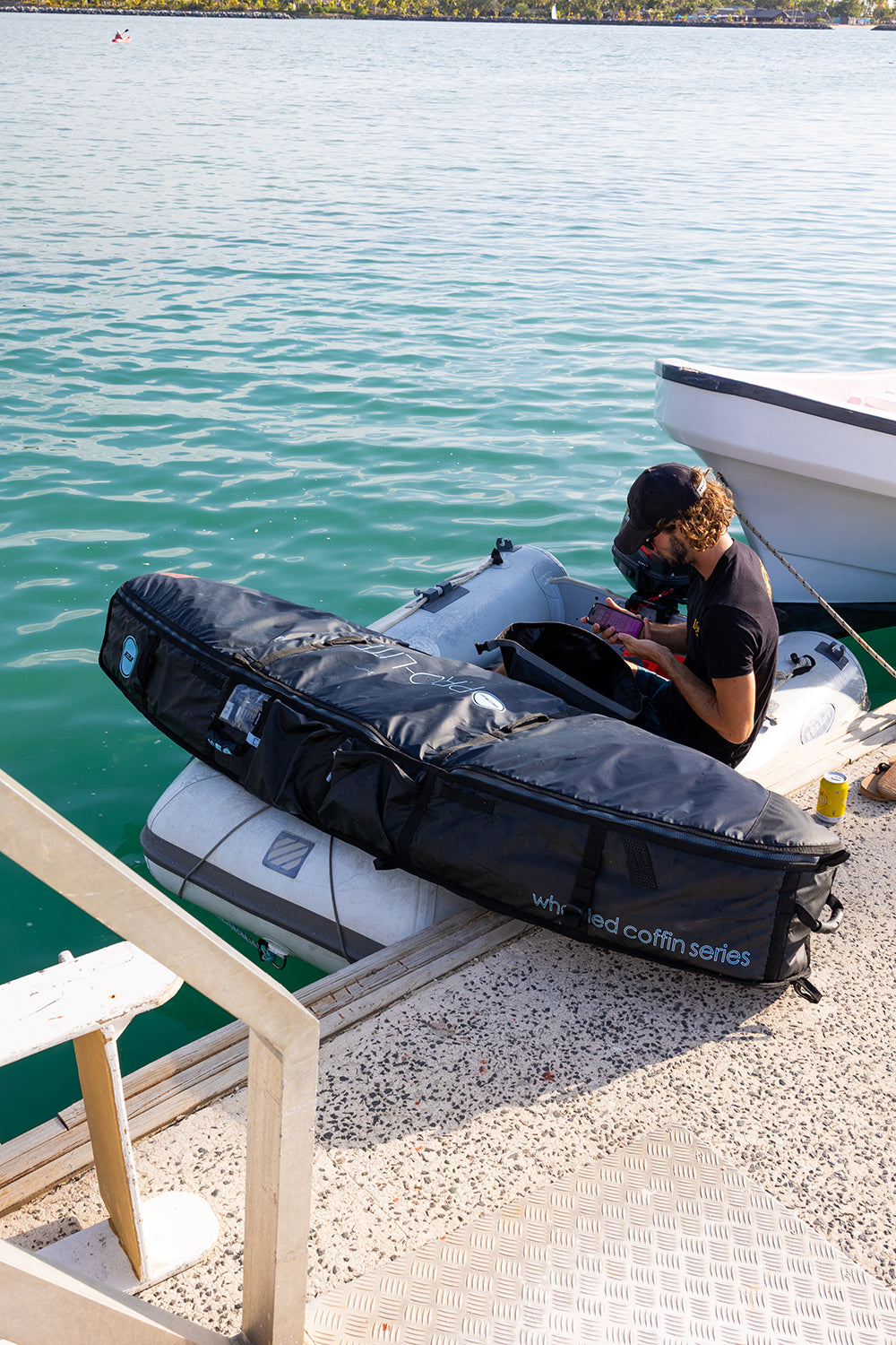 Ben Weiland wheeled coffin surfboard travel bag on boat.