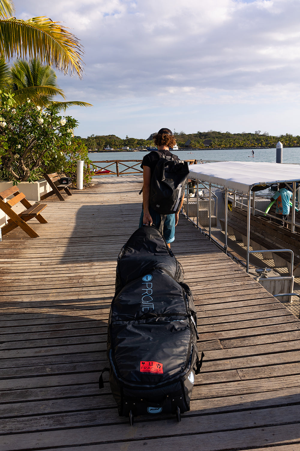 Ben Weiland wheeled coffin surfboard travel bag on dock.