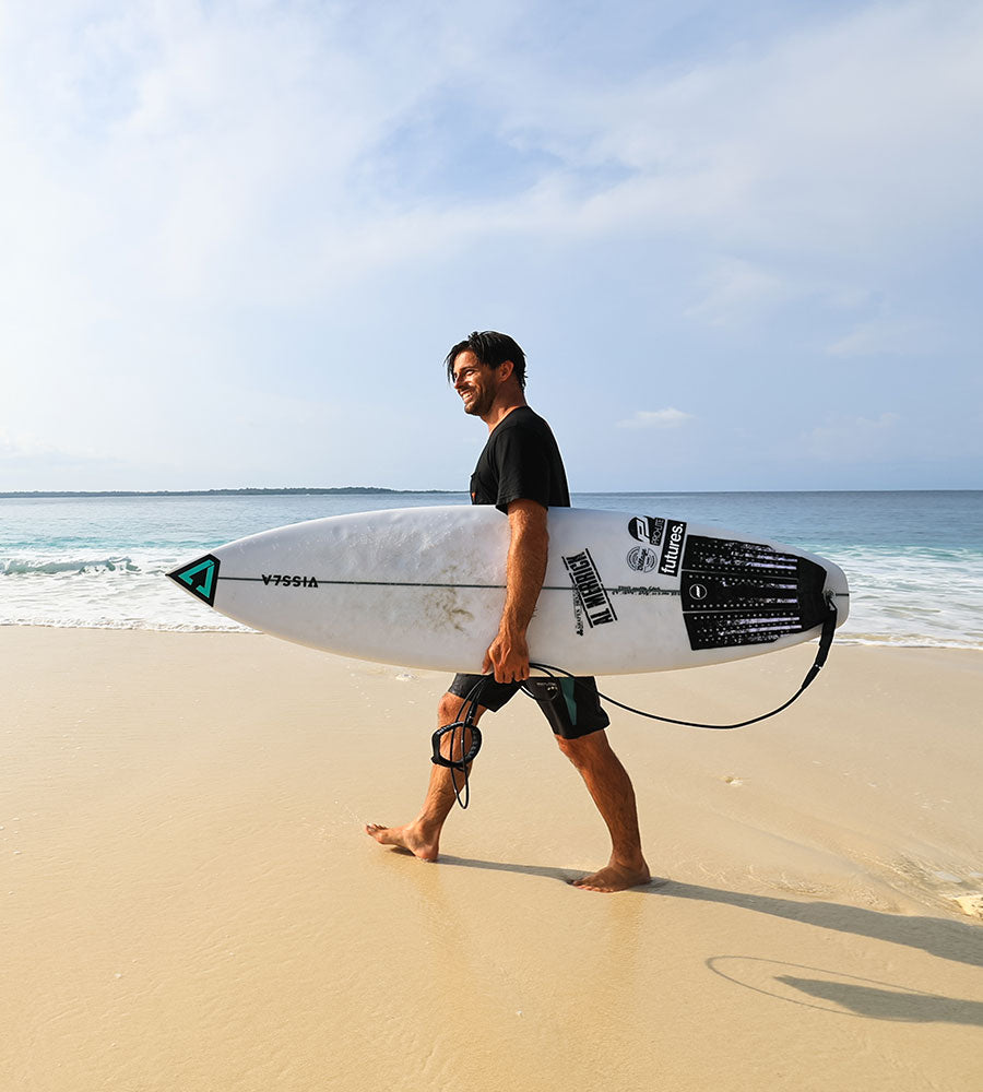 Cam Richards walks with surfboard traction pad.