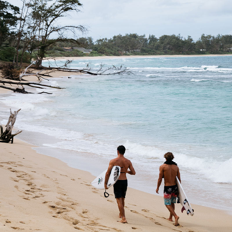 surfboard bags, surfers on beach