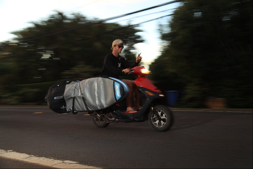 Josh Kerr rides moped with quick strike bag on surf rack