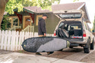 Surfer carry's rhino surf travel bag to car. surfboard bag, surfboard travel bags