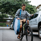 keanu asing riding bike with wide ride day bag.