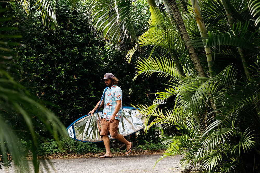 Timmy Reyes walks with wide ride surfboard day bag.